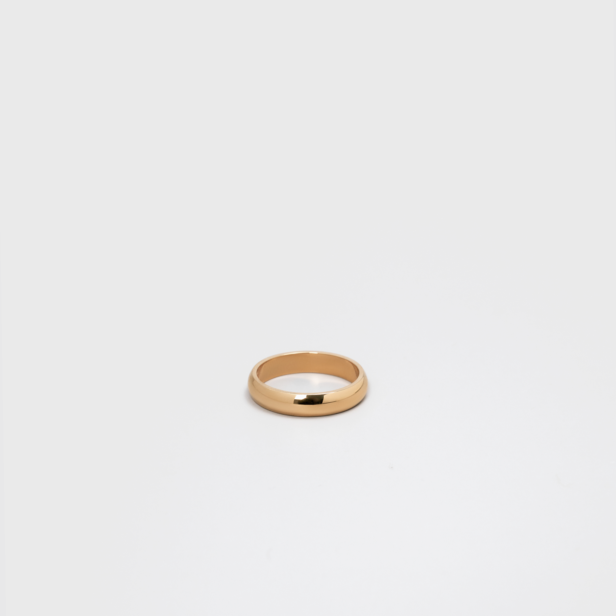 Gold ring on a light gray background